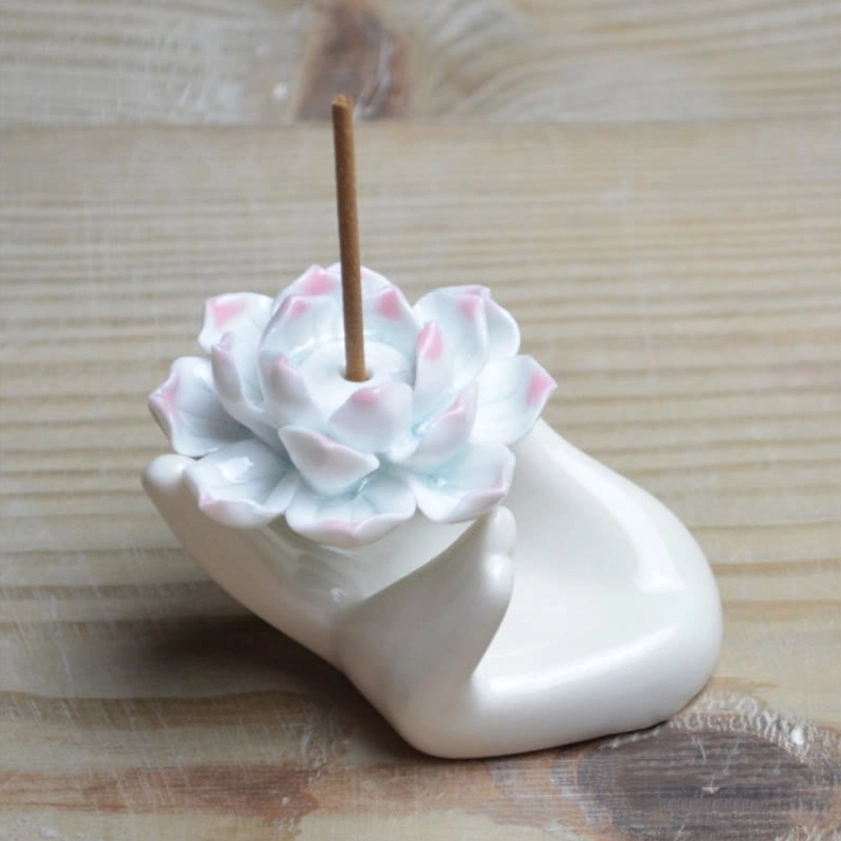 Front three-quarter perspective of compact white ceramic lotus incense stand with soft pink-white lotus design for mindfulness practice