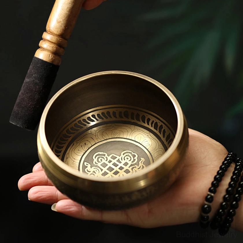 Close-up detail of handcrafted Buddhist singing bowl with engraved inner patterns held in hand