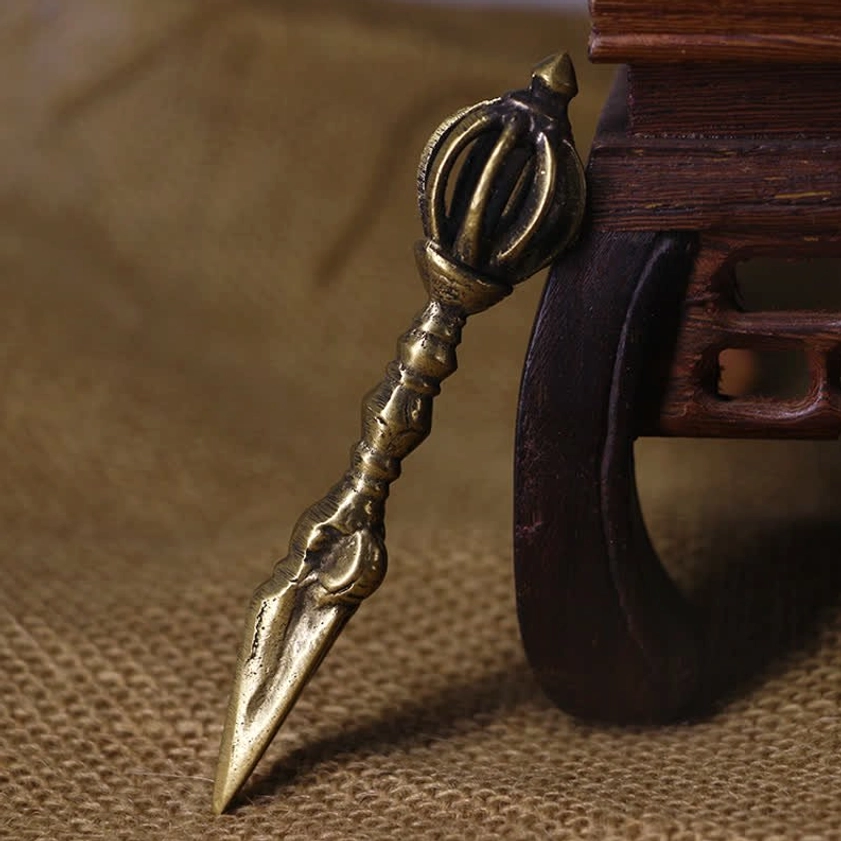 Handmade copper vajra dorje with nine-pronged crown and carved ridged handle, displayed on burlap fabric with vintage brass tone finish