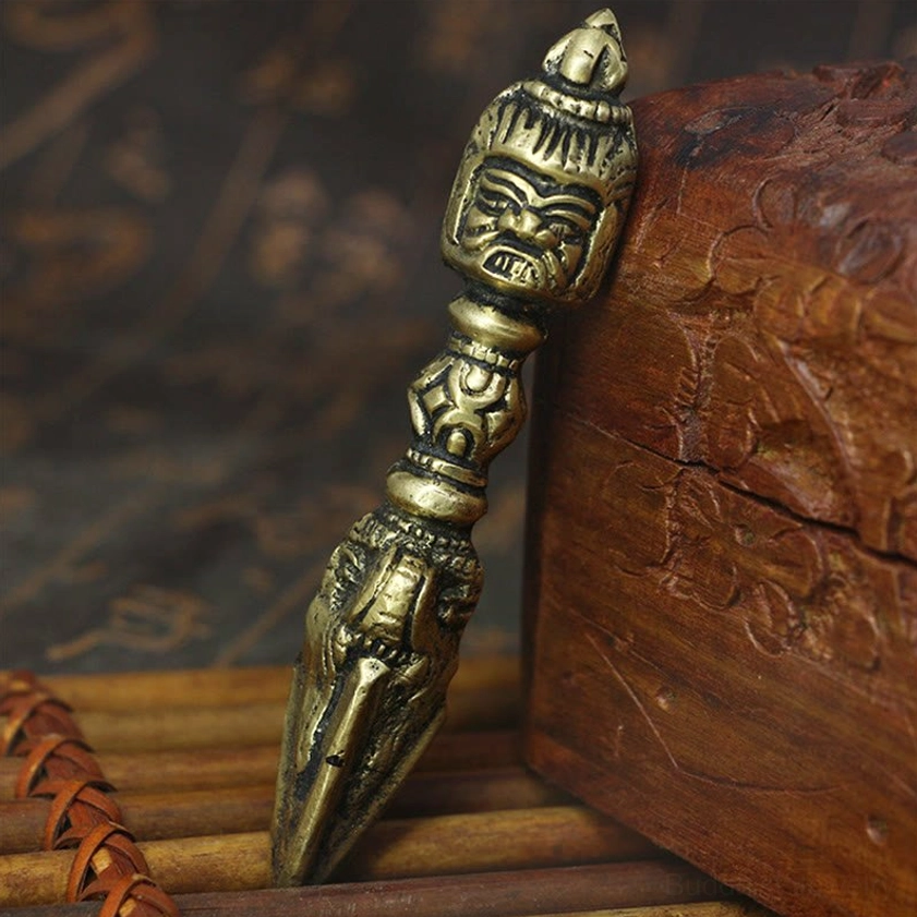 Handmade copper vajra dorje meditation tool with intricate engraved patterns, displayed on wooden box with antique bronze patina