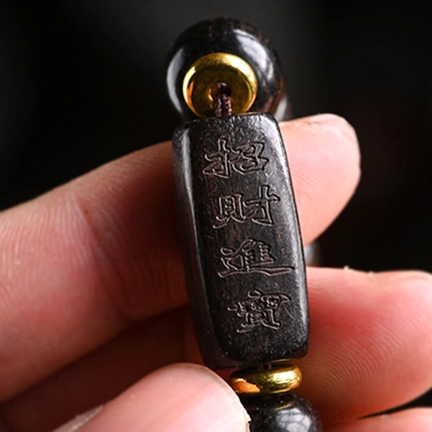 Handmade ebony wood Buddhist bracelet with gold spacer rings and carved charm beads for daily wear