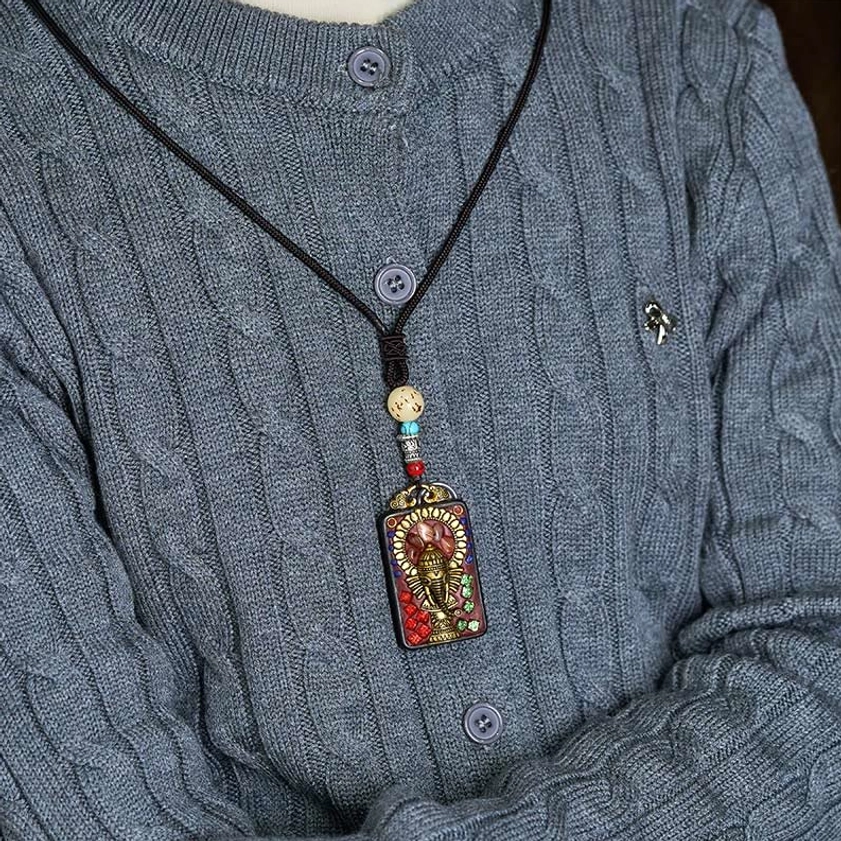 Handmade Ganesha pendant showing artisanal quality and natural wood characteristics
