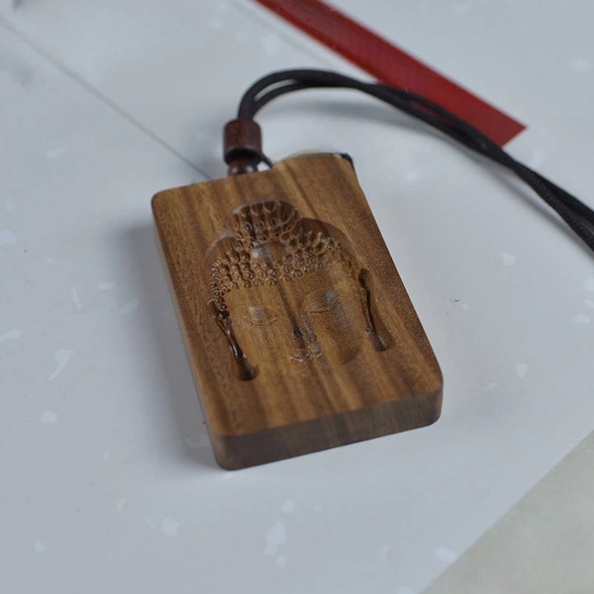 Authentic handmade green sandalwood Buddha pendant highlighting natural wood grain texture and artisan carving craftsmanship