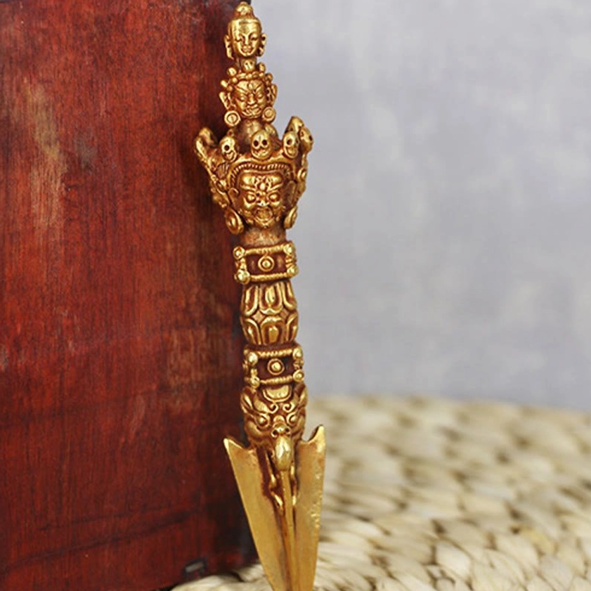 Front standing view of authentic copper Vajra Dorje meditation tool with warm bronze-gold color and intricate religious-themed relief carvings