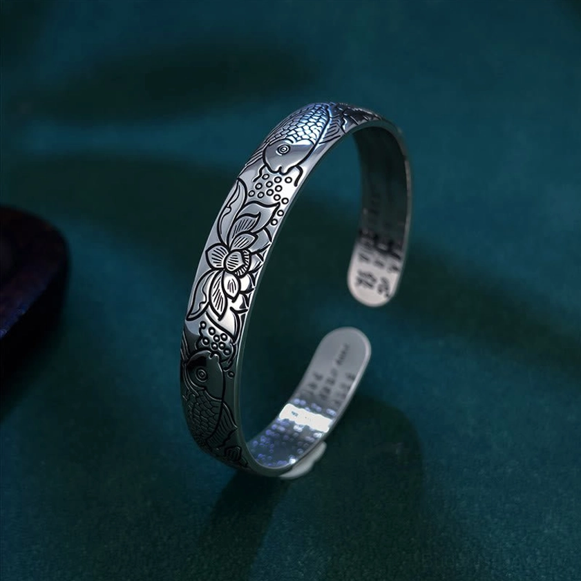 Side profile view of copper bangle showing engraved Heart Sutra scripture and embossed koi fish lotus pattern