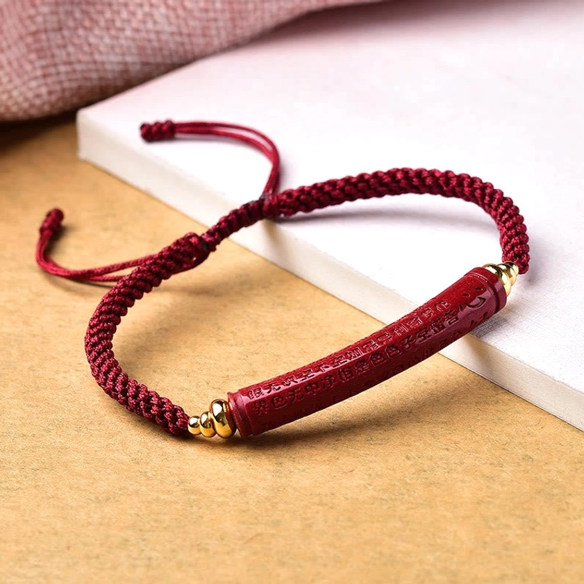Cinnabar engraved Heart Sutra Buddhist bracelet with red woven cord and gold hardware detail