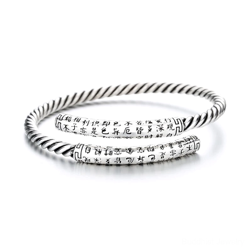 Top-down flat lay of Heart Sutra copper bangles featuring engraved Chinese Buddhist sutra text and twisted silver rope texture pattern, white background