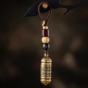 Heart Sutra copper keychain with engraved Buddhist sutra barrel pendant and braided beaded cord, overhead view