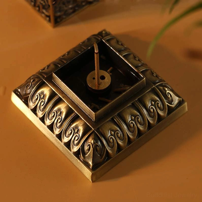 Square incense holder base detail with carved lotus border and incense insertion slots for spiritual practice