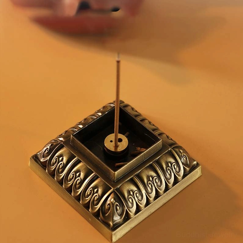 Copper incense burner with vertical incense stick inserted in dual incense holders, top view