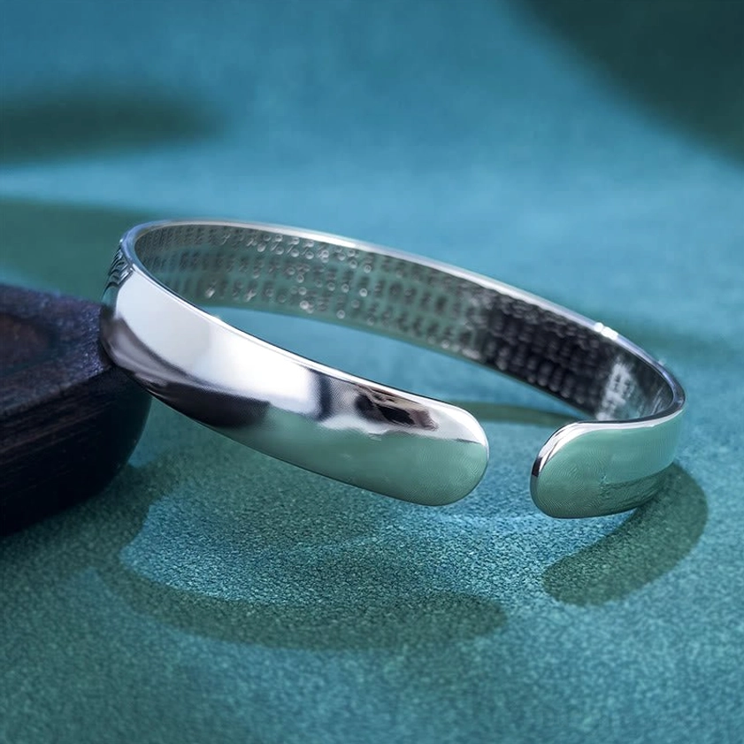 High side view of plain copper open cuff bangle showing inner Heart Sutra engraving and smooth polished exterior