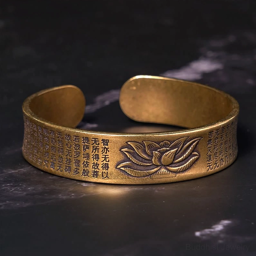 Heart Sutra lotus brass bracelet front flat view featuring antique bronze finish with embossed lotus and complete sutra text