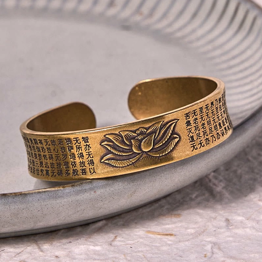 Buddhist lotus cuff bracelet side view displaying retro brass color with engraved lotus and Heart Sutra inscriptions