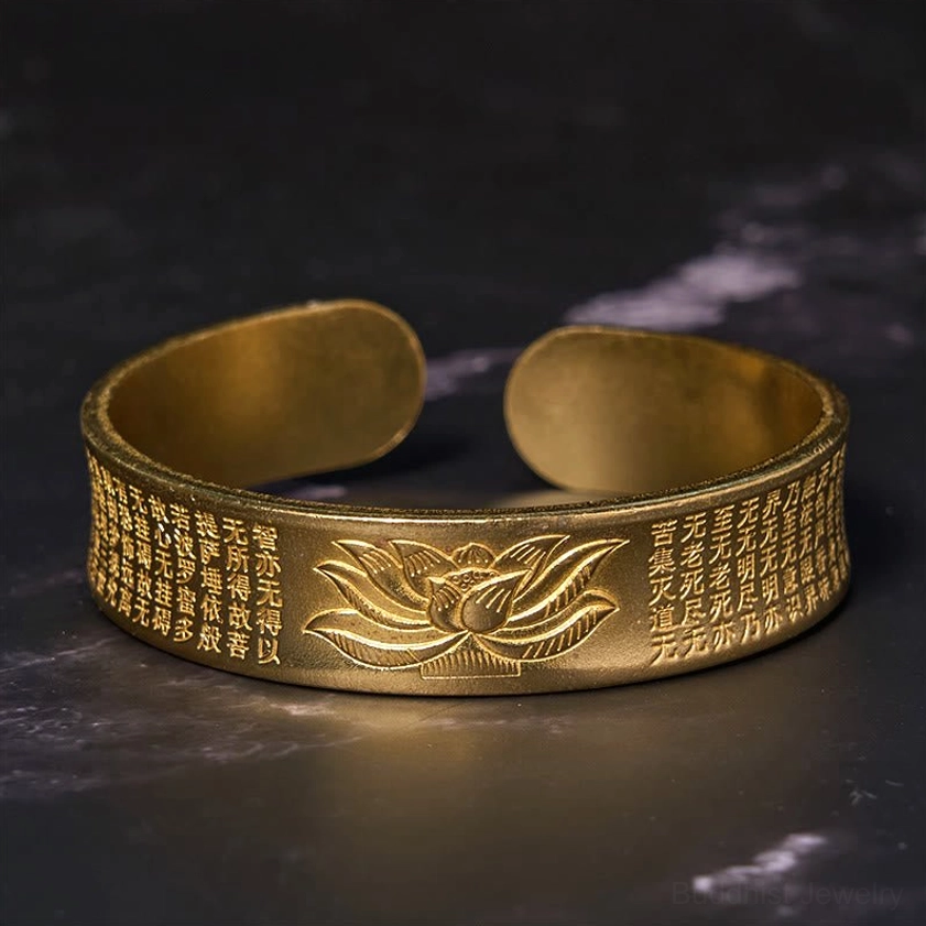 Heart Sutra lotus brass cuff bracelet front view showing antique bronze tone with 3D lotus relief and complete circular sutra engraving