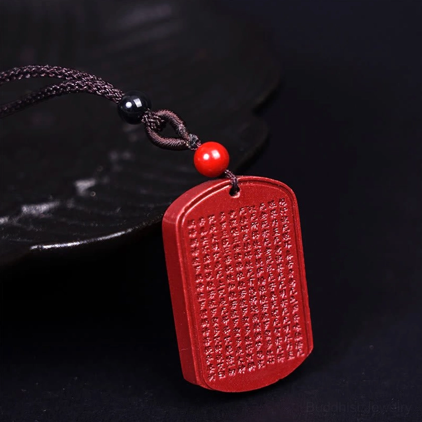 Cinnabar heart sutra pendant flat lay showing complete engraved sacred text