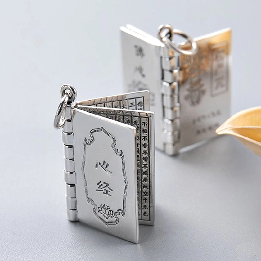 Silver Buddhist Heart Sutra book pendant with flipable multiple pages and lotus engraving, side view angle