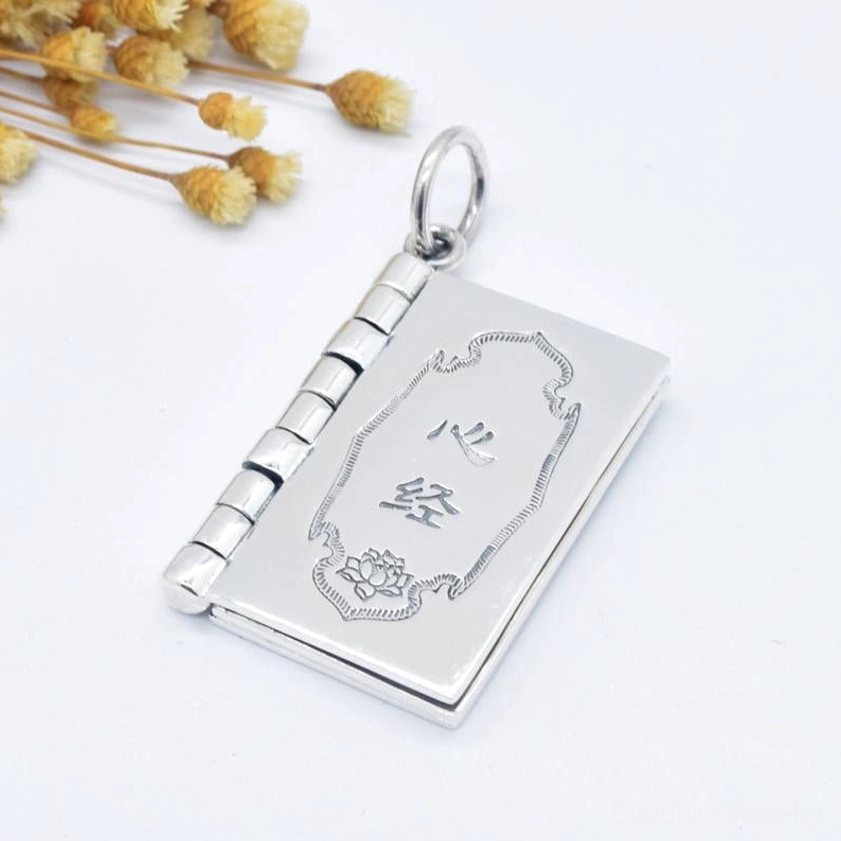 Closed silver Heart Sutra book pendant featuring engraved lotus flower pattern and hinged flip mechanism