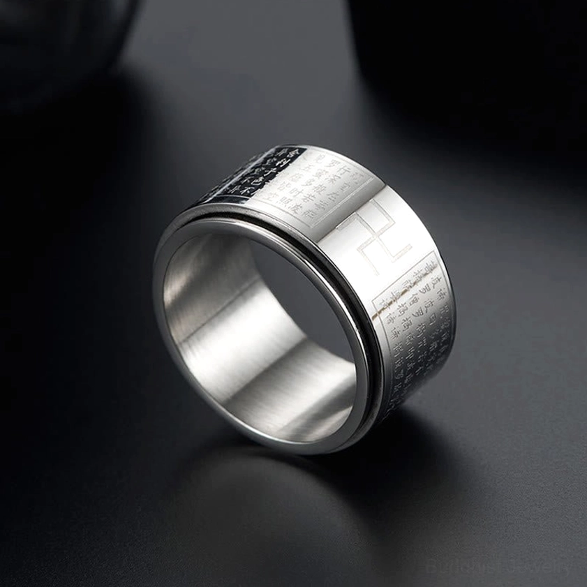 Close-up side view of silver Heart Sutra Swastika rotatable ring with brushed metal finish and engraved Buddhist text