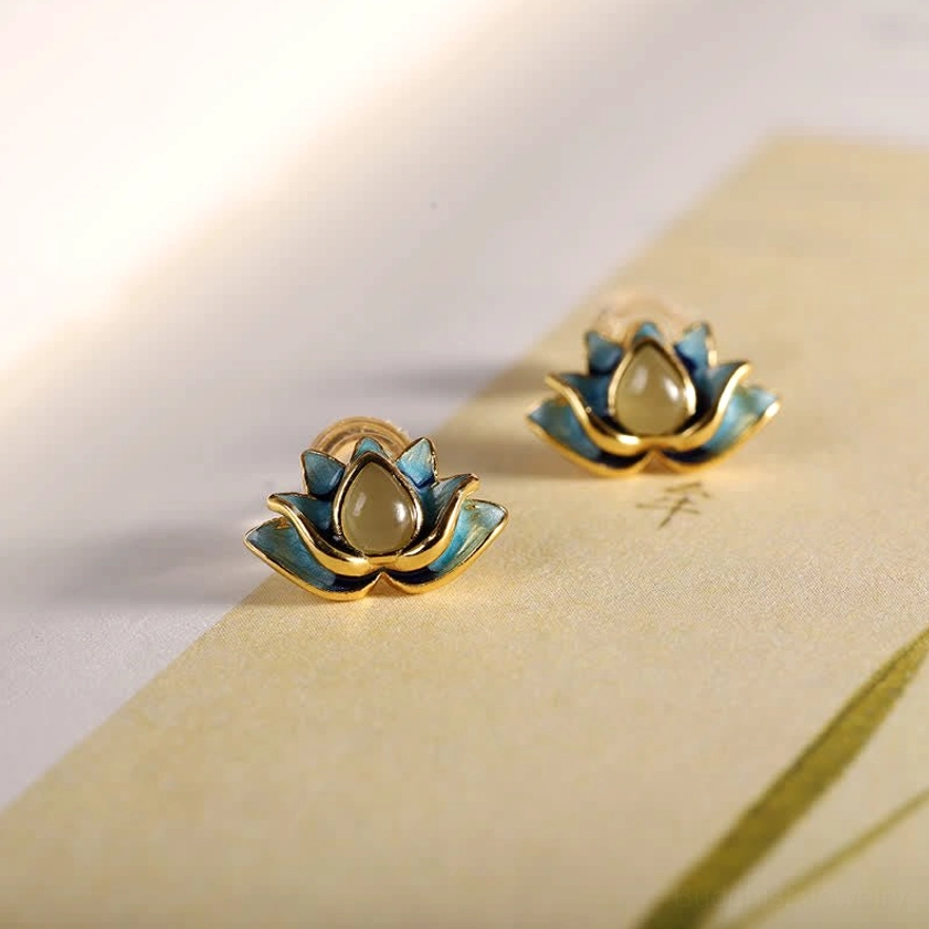 Hetian cyan jade lotus stud earrings overhead flat lay with blue jade and gold trim on decorative background