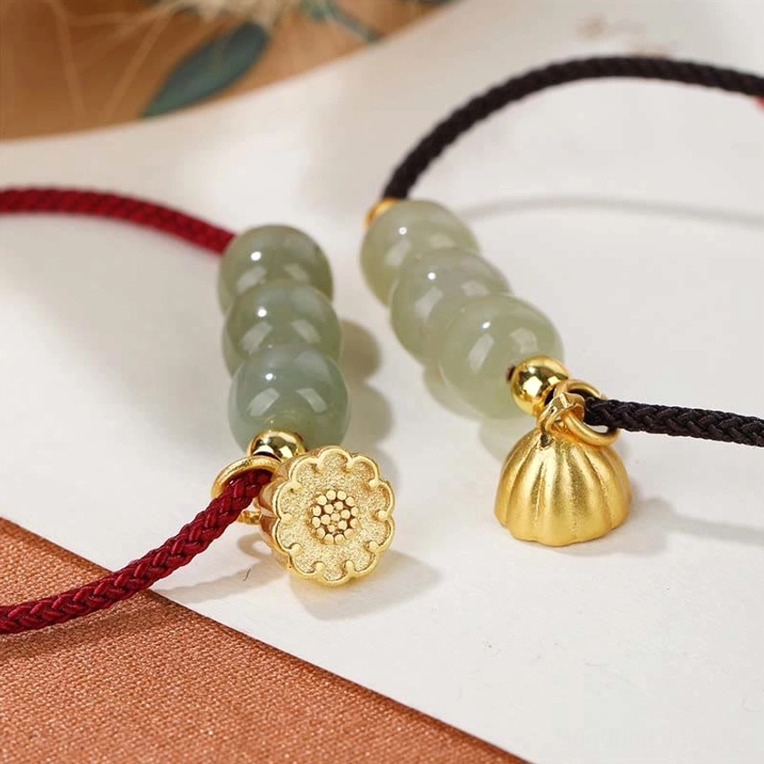 Detailed close-up of jade beads and charm components showing light green hetian jade smooth finish, dual gold pendant styles, and handcrafted quality of Buddhist bracelet