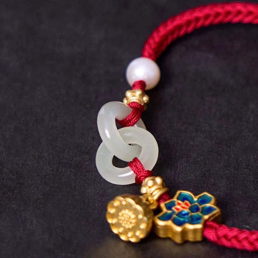 Close-up side view of complete Buddhist jade bracelet showing white pearl, jade double ring, enamel lotus, and gold lotus pendant