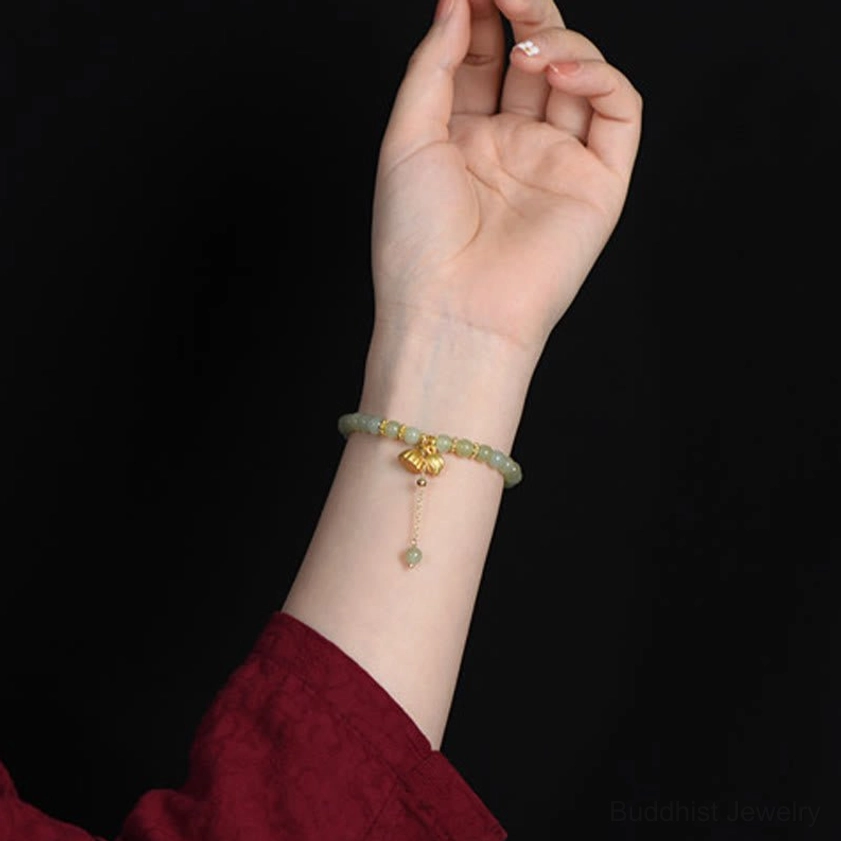 Woman wearing hetian jade lotus bracelet on wrist with red sleeve, lifestyle wear shot