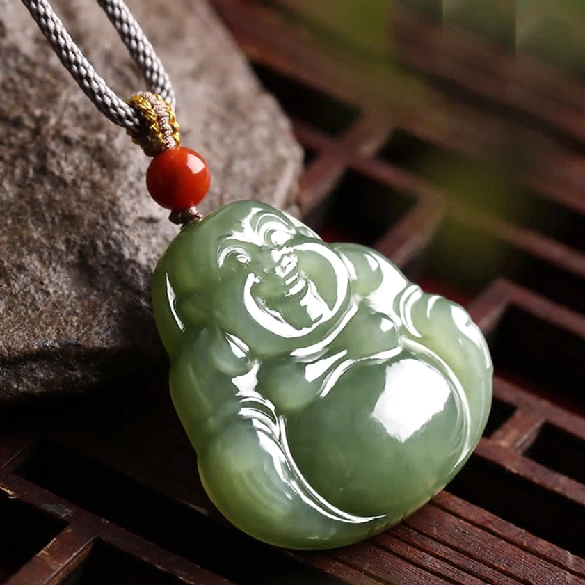 Maitreya Buddha jade pendant necklace aerial view with golden knot on ornate wooden lattice background