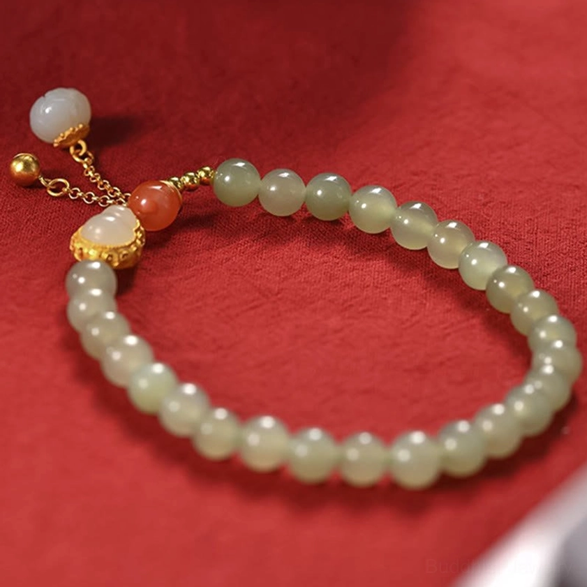 Complete hetian jade gourd lotus bracelet on red background overhead view