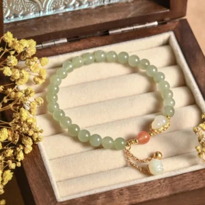 Hetian jade gourd lotus bracelet overhead flat lay with dried flowers on wooden jewelry tray