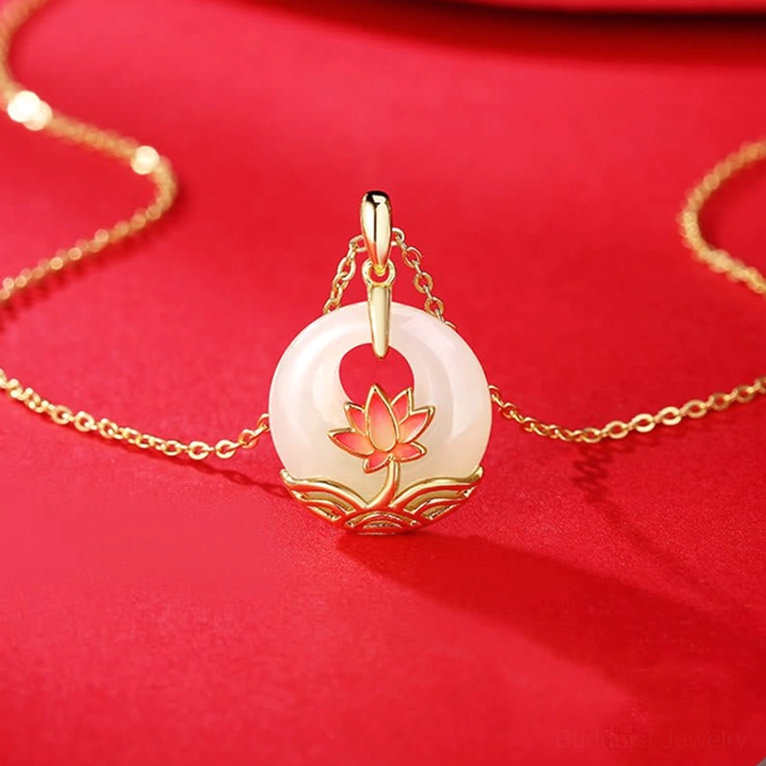 Complete hetian white jade lotus necklace with sterling silver chain laid flat on red fabric, full product view