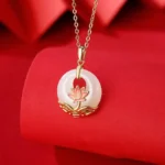 Hetian white jade lotus flower pendant necklace with sterling silver, close-up front view on red fabric background showing hand-carved lotus detail
