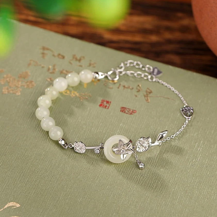 Silver-toned Hetian jade peace buckle bracelet with star-shaped metal charms on vintage calligraphy paper
