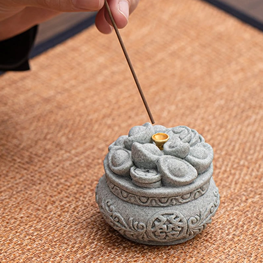 Hand placing incense stick into handcrafted Buddhist incense burner showing ease of use