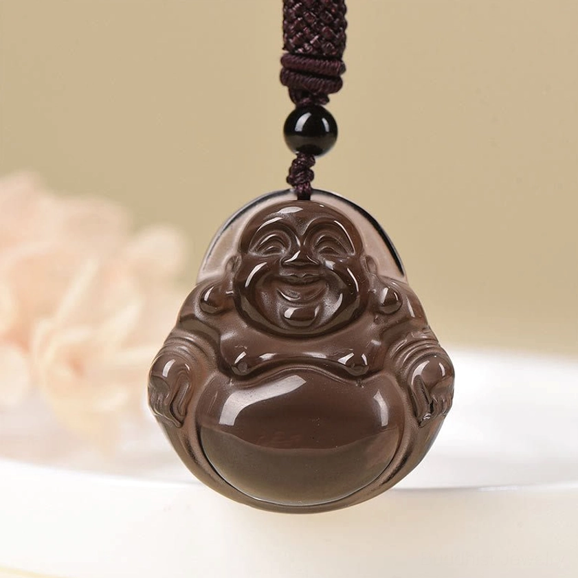 Ice obsidian laughing Buddha pendant close-up with polished dark brown finish and woven accent cord on light background