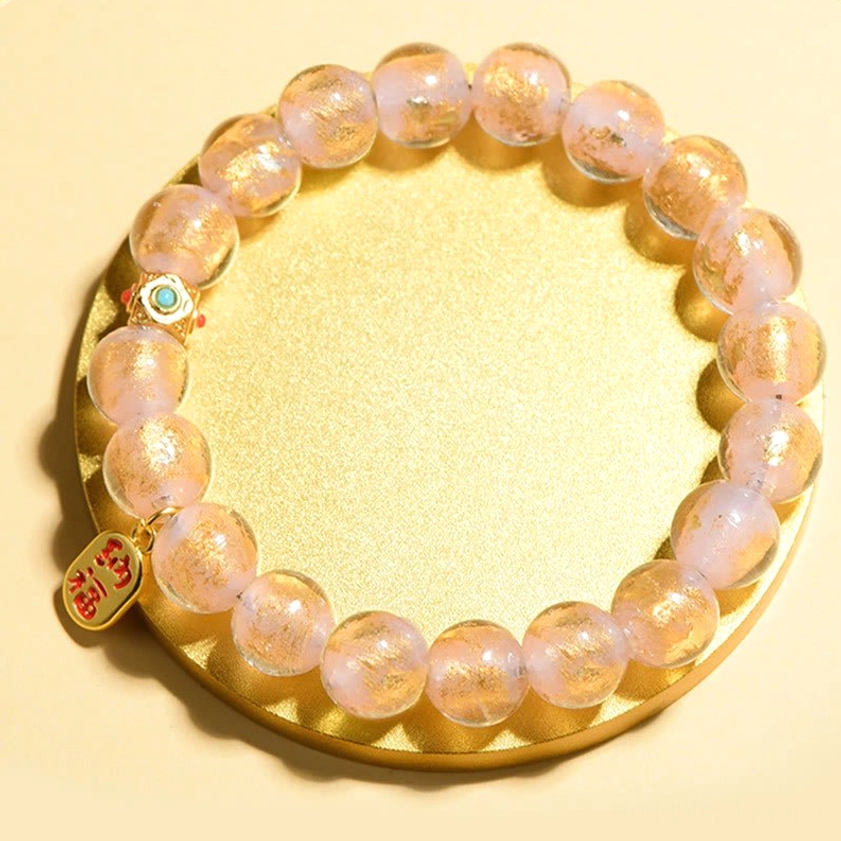 Pale pink glitter incense ash liuli glass beads with gold fortune charm on gold tray display
