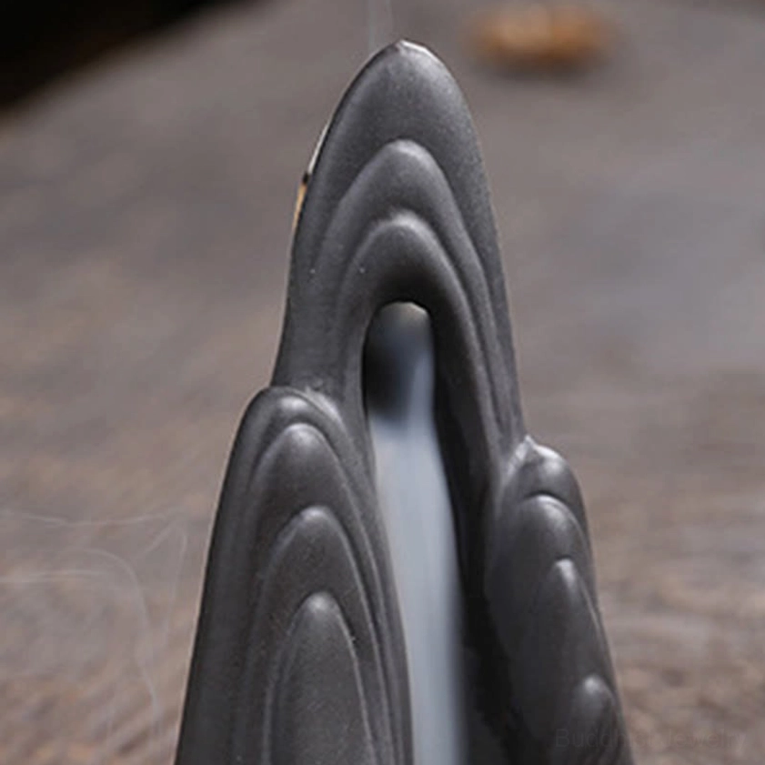 Close-up of ceramic mountain incense burner texture showing handcrafted layered pattern and matte finish