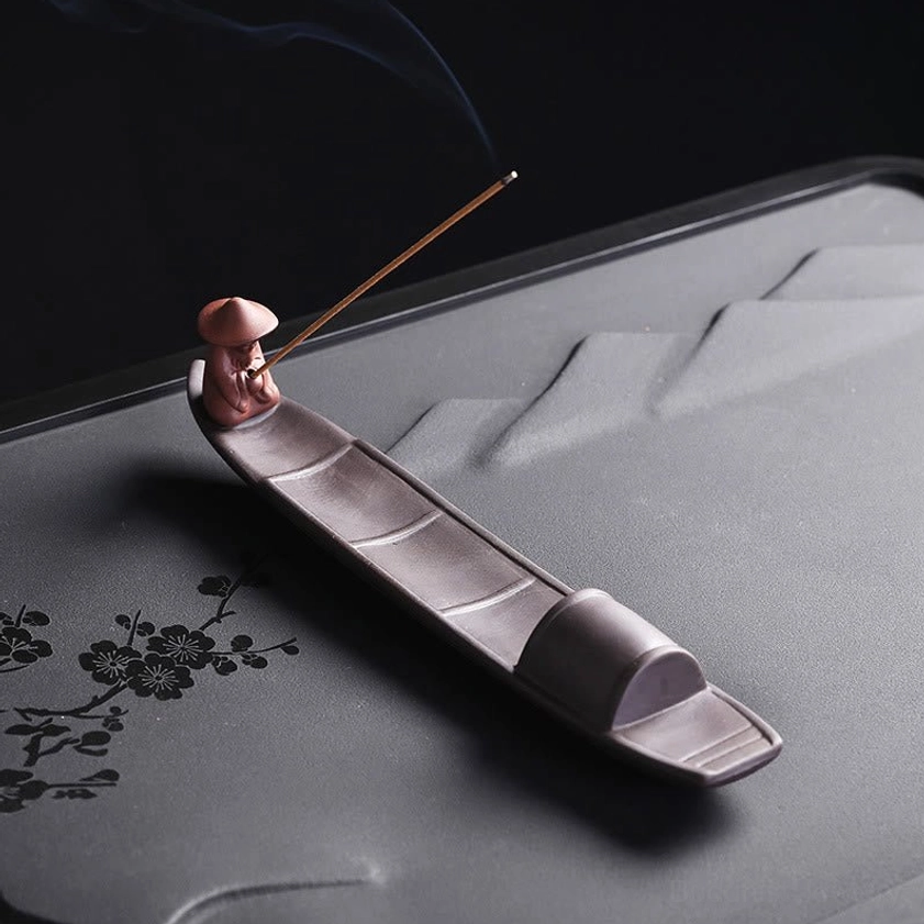 Overhead view of handmade fisherman boat incense burner with enclosed cabin and reddish-brown fisher figurine on bow, perfect for meditation spaces