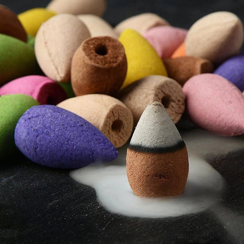 Flat lay display of assorted backflow incense cones in multiple vibrant colors with aromatic smoke effect, product bundle showcase