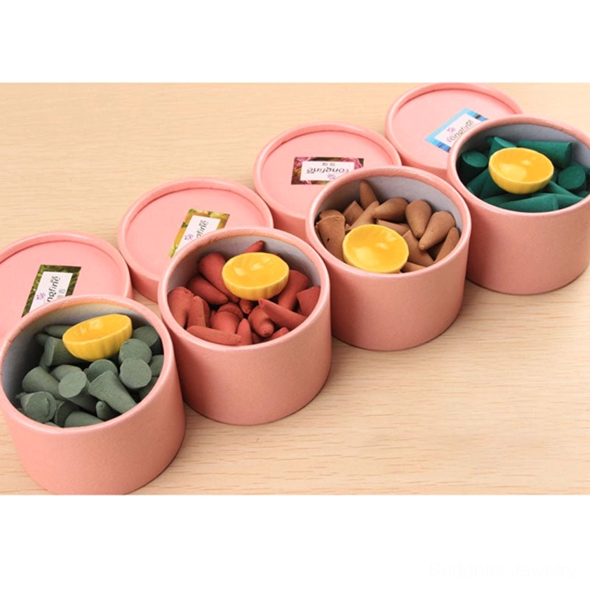 Opened incense cone containers showing assorted colored cones with yellow ceramic lotus holders