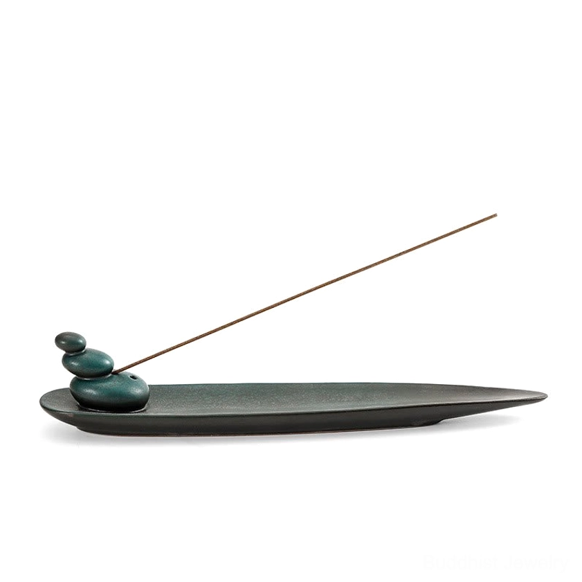 Minimalist leaf-shaped Buddhist incense holder isolated on white background dark teal matte finish