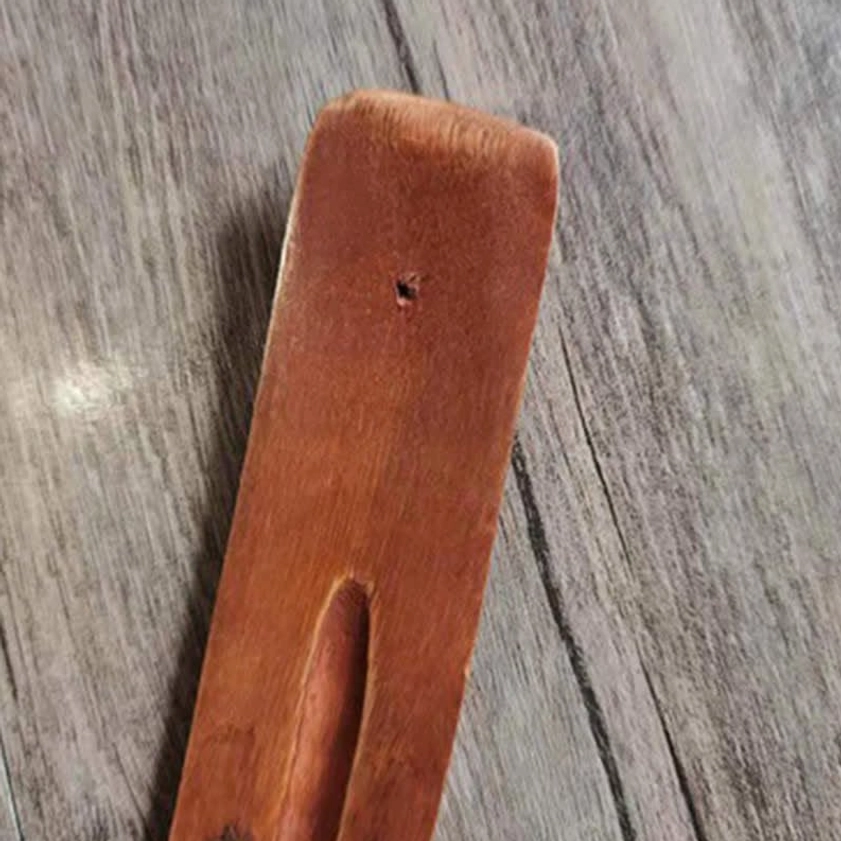 Handmade wood incense holder side section close-up rounded edge hanging hole carved slot