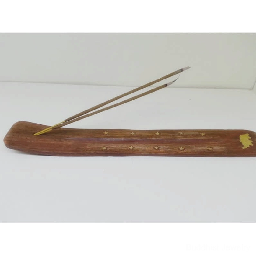 Buddhist wooden incense holder side view with gold star details holds two incense sticks