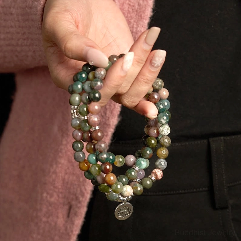Woman wearing 108-bead Indian agate mala bracelet with lotus pendant in casual daily outfit