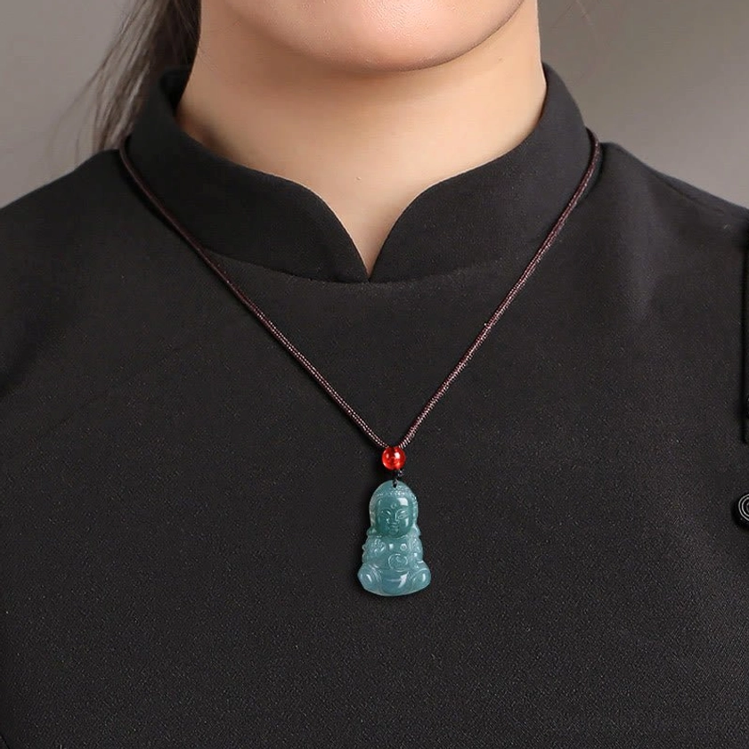 Worn jade Buddha pendant necklace on model showing how pendant sits at collarbone with black rope cord