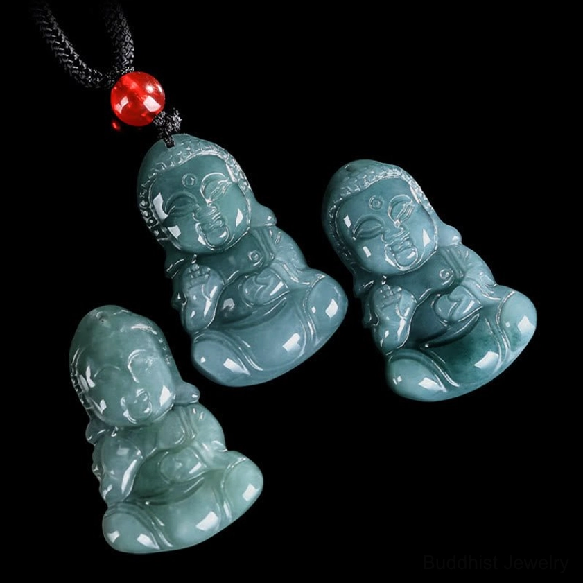 Multiple handcrafted jade Baby Buddha pendants with black cords and red accent beads flat lay