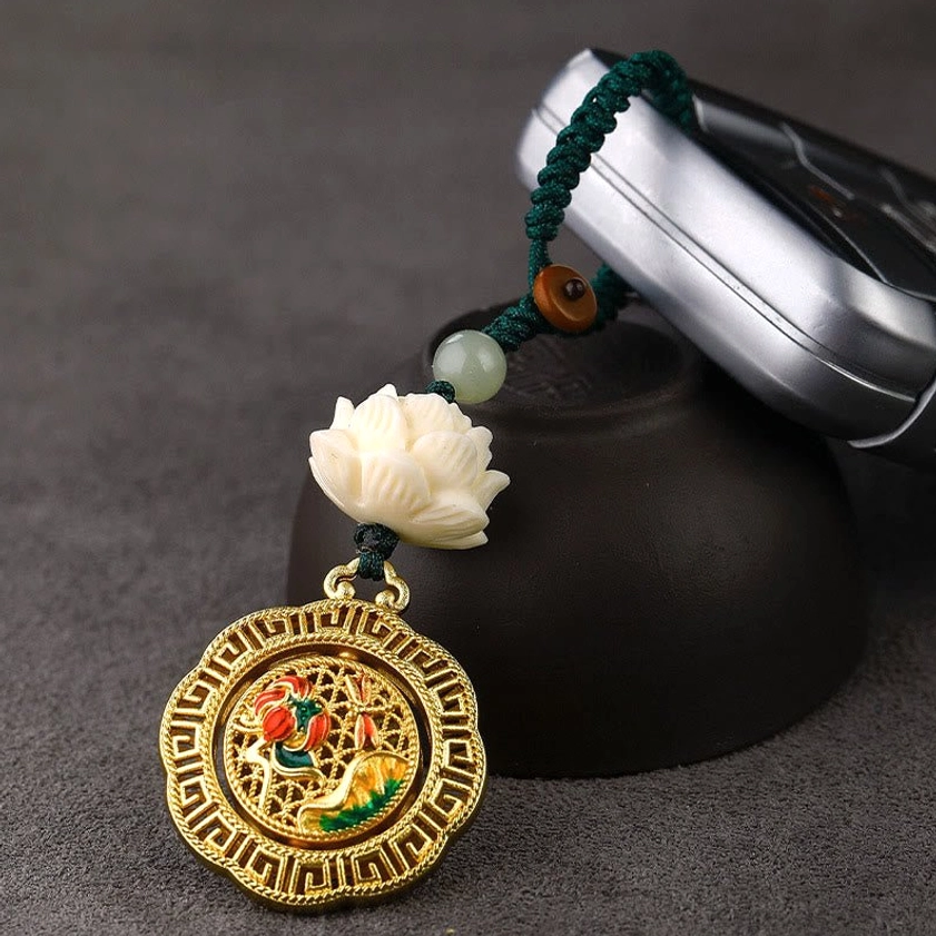 Hetian jade bodhi seed keychain lifestyle shot with car key and ceramic bowl, showing rotatable copper pendant and green rope