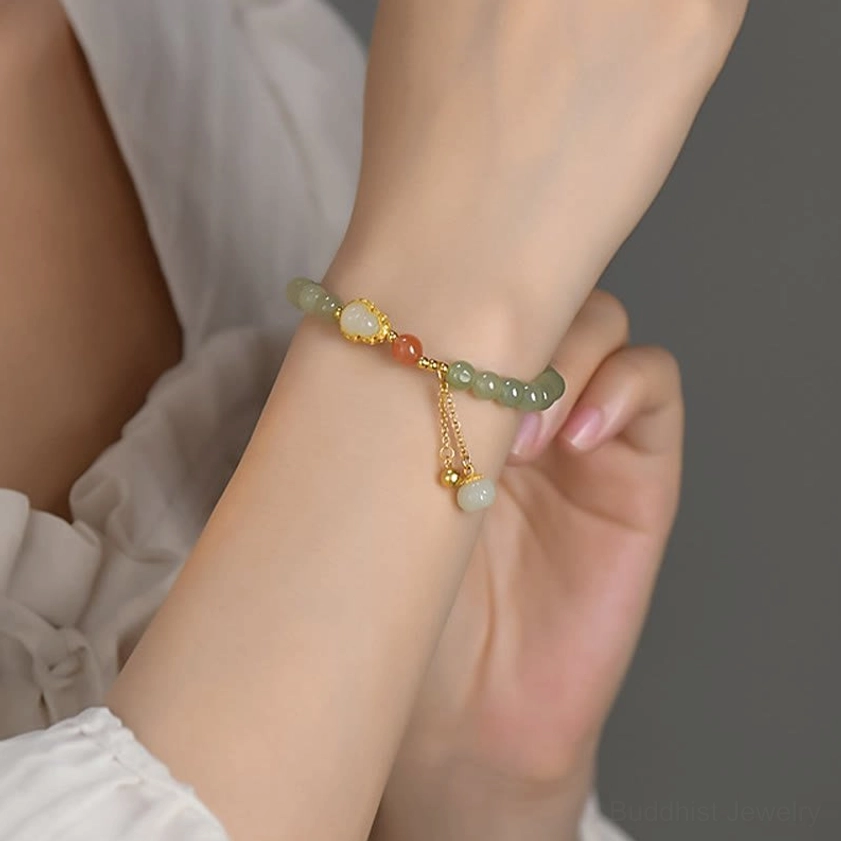 Hetian jade buddhist bracelet close-up on wrist with gold-toned clasp