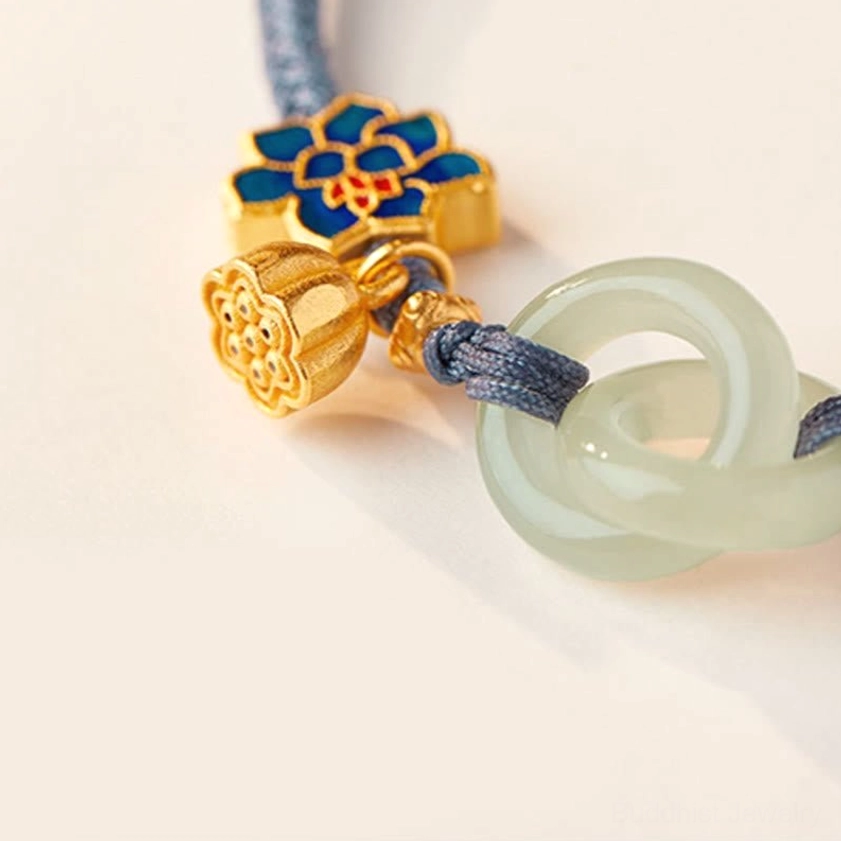 Hetian jade bracelet with pearl and lotus charm accents on dark background