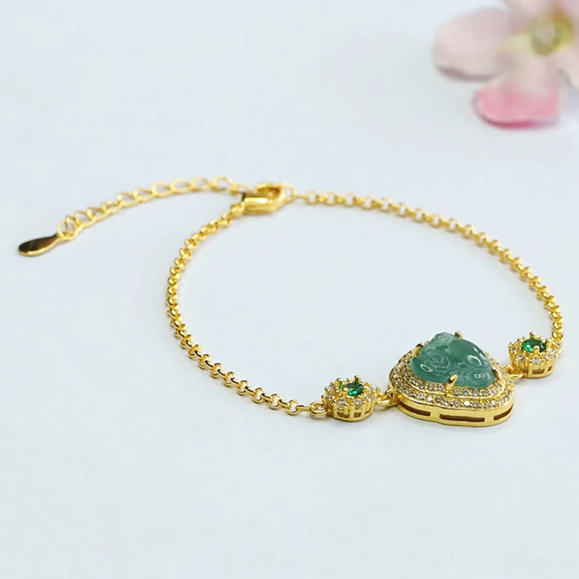 Laughing Buddha jade bracelet flat lay on light background with pink petals showing full circular design and adjustable extender