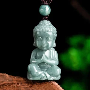 Natural jade baby Buddha amulet pendant with prayer mudra hands, worn on brown cord with jade bead, celadon green stone carved in meditation pose